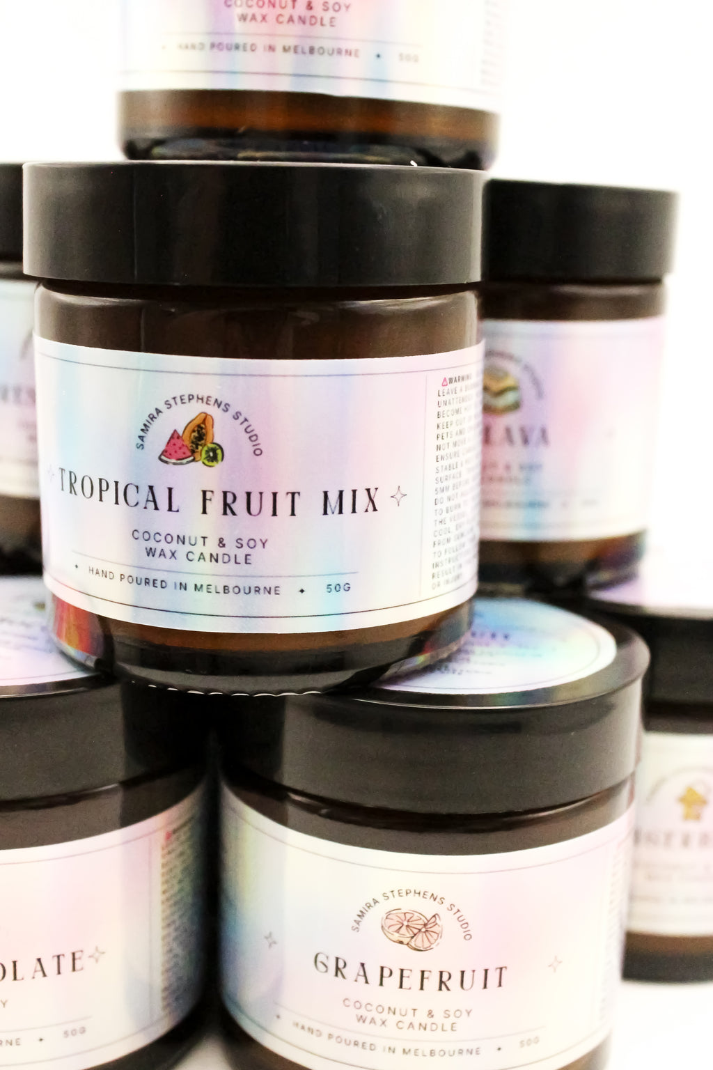 Collection of soy coconut wax candles in glass jars with labels on a white background